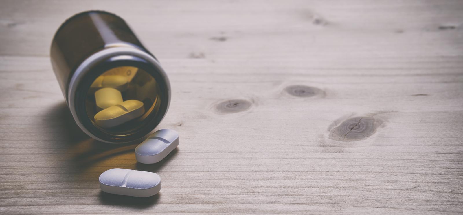 bottle of pills spilling on a table